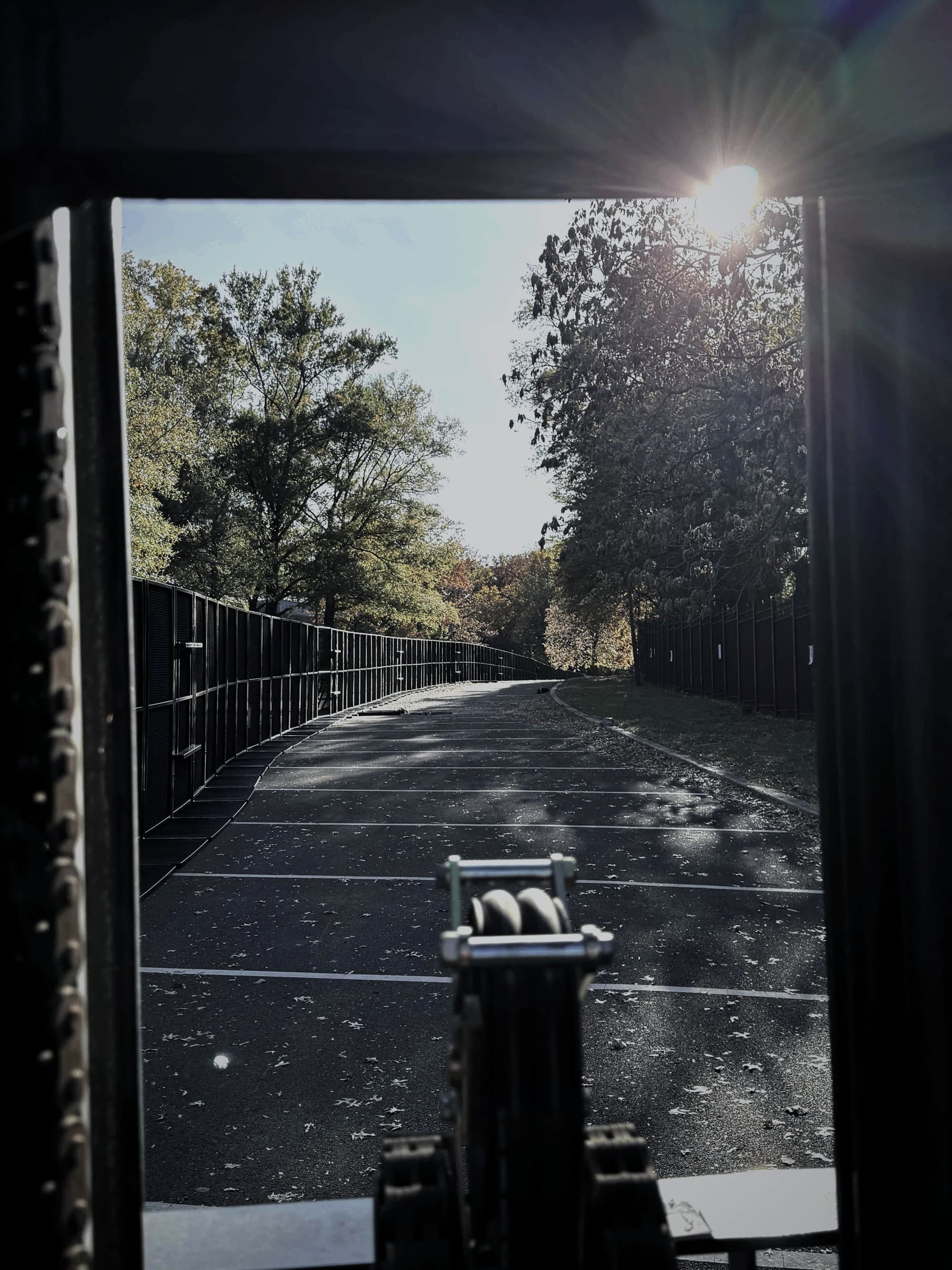 Security gate at dusk with sun flare through the perimeter line