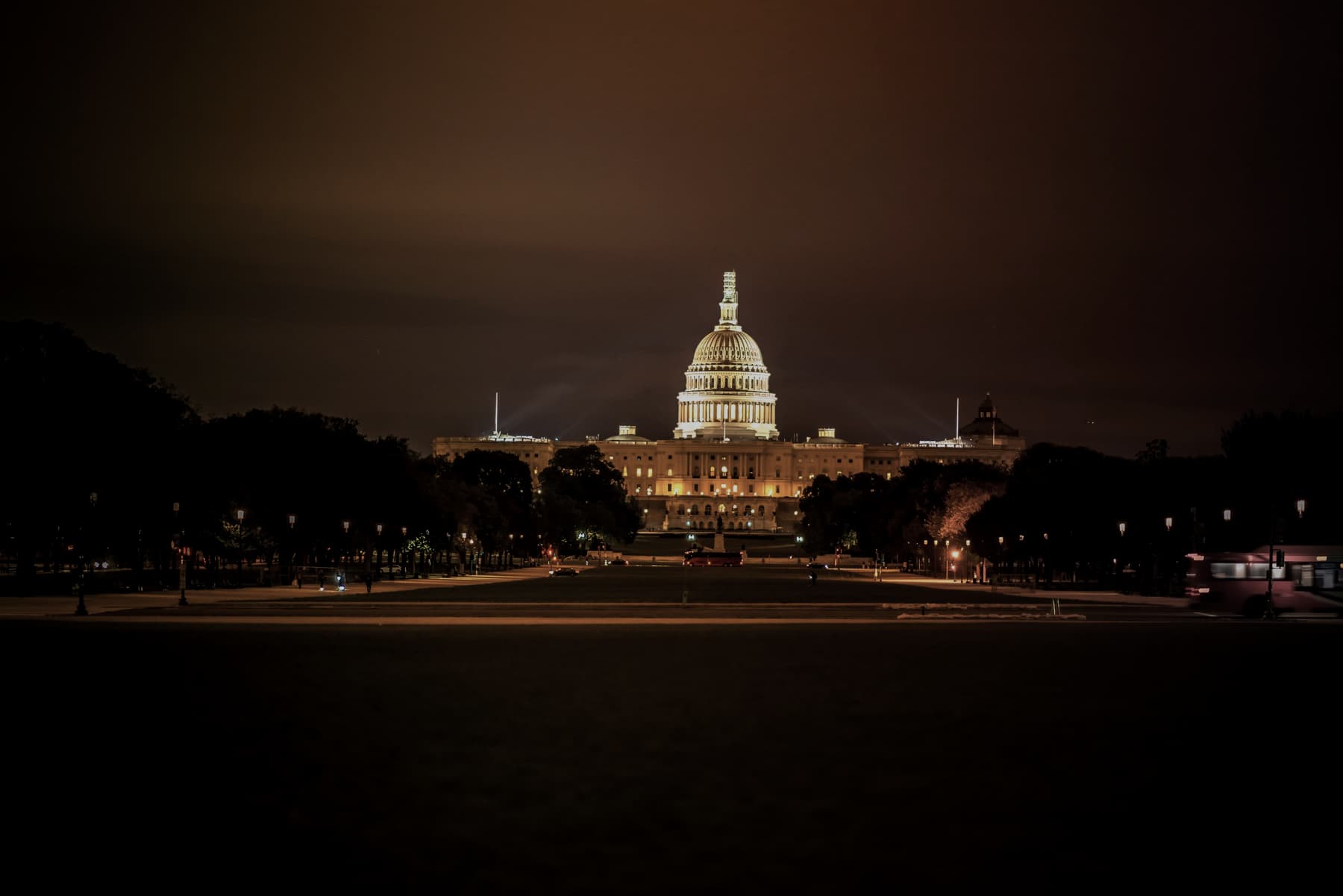 The United States Capitol illuminated at night across the National Mall