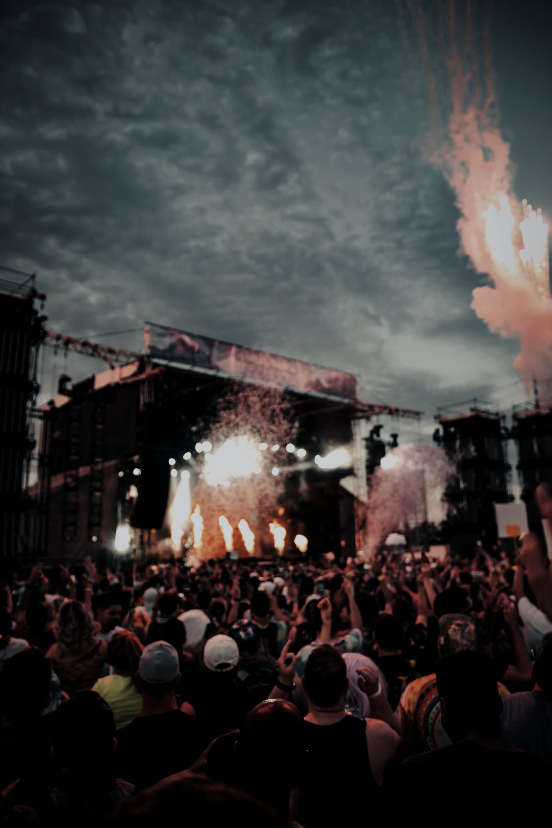 Dense night-time festival crowd in front of a lit main stage