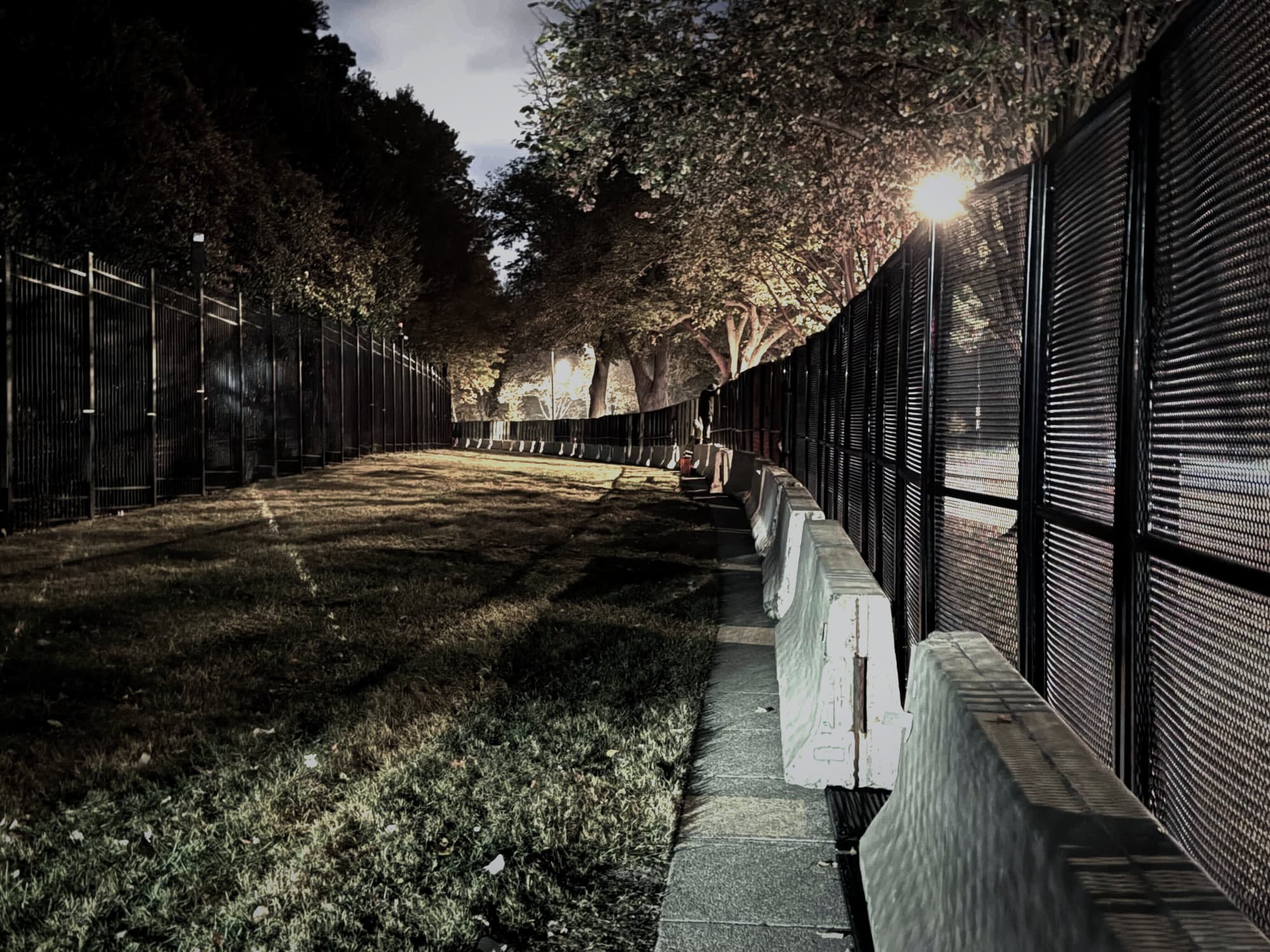 RMR Pro anti-climb perimeter fencing deployed at night along a lit tree-lined route