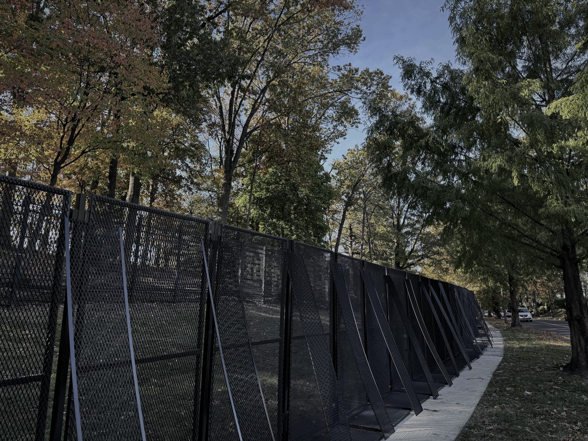 Long curved run of black anti-climb security fencing following a sidewalk